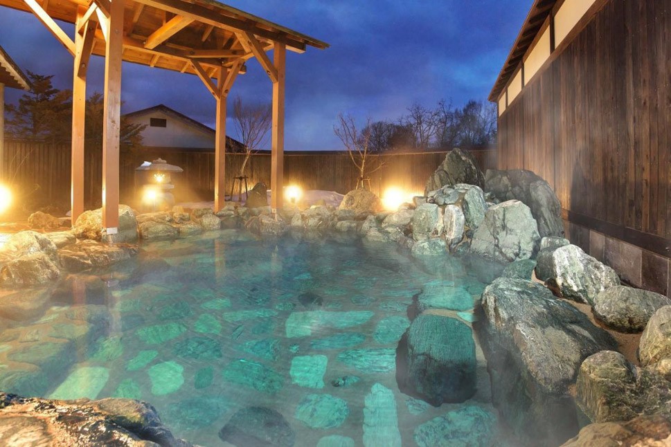 Bể tắm tại Kusatsu Onsen tận dụng triệt để đá tảng, đồ gỗ để du khách hòa mình vào thiên nhiên.