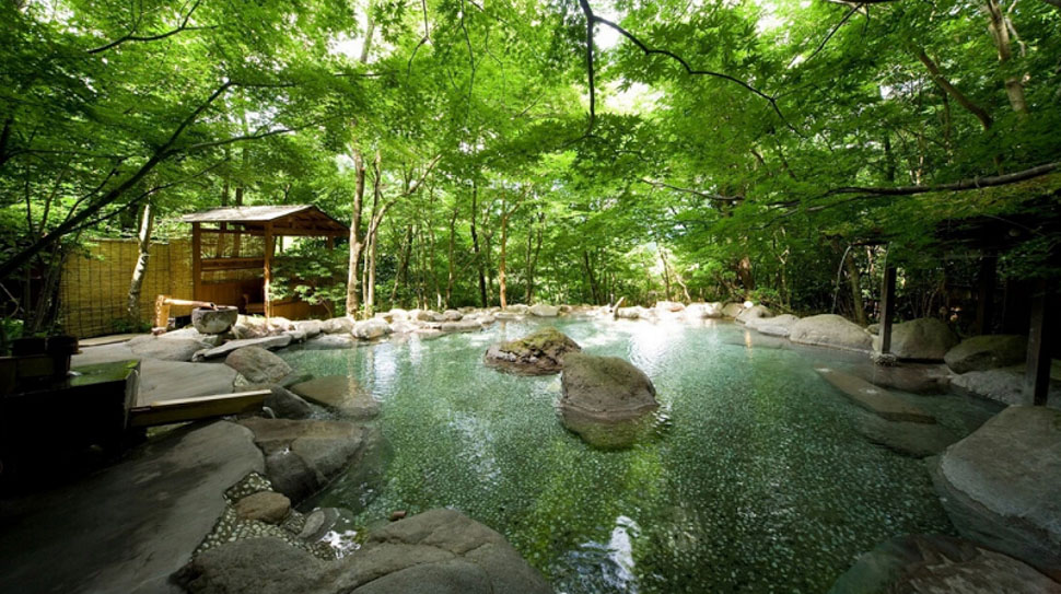 Bể tắm onsen ngoài trời diện tích rộng, xanh mát, thơ mộng.
